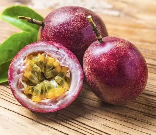 Whole and freshly cut maracuyá passion fruit showing its golden pulp and seeds